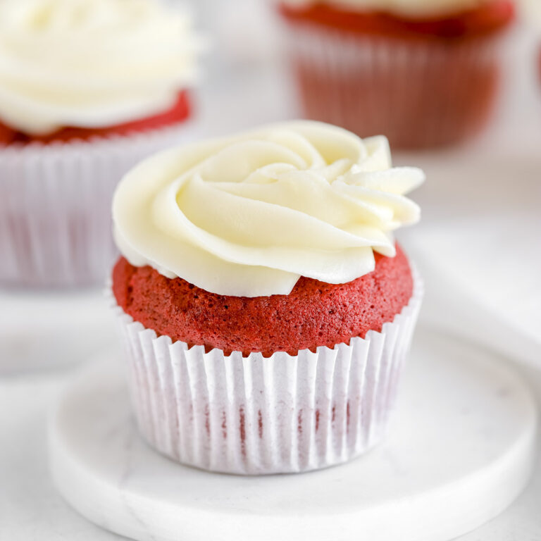 Red velvet cupcakes decorated with white frosting.