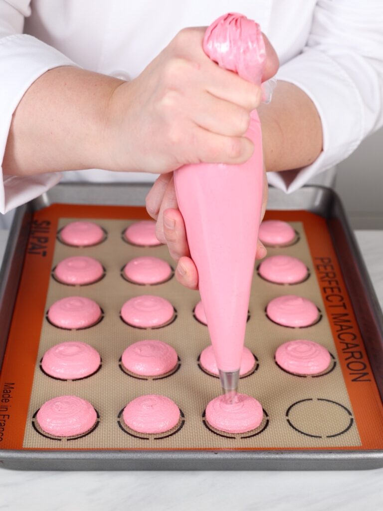 Hand holding a piping bag with macaronage.