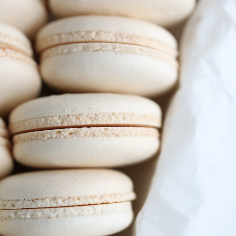 White macaron shells in the box.