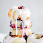 Stock of baked blueberry donuts with the glaze.