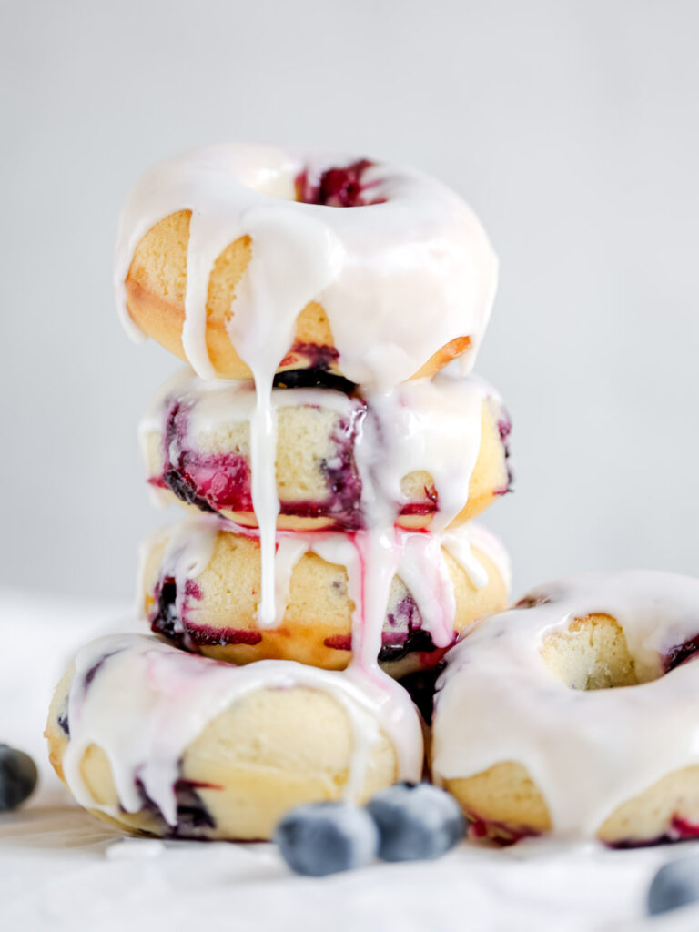 Stock of baked blueberry donuts with the glaze. 