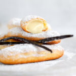 Eclairs are dusted with the powdered sugar and cut in half.