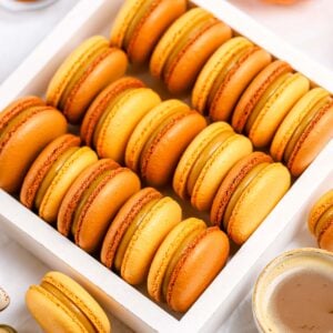 Brown and orange macarons in the box.