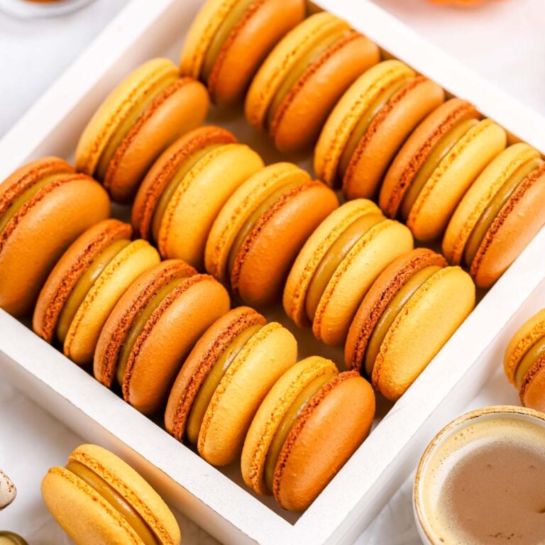 Brown and orange macarons in the box.
