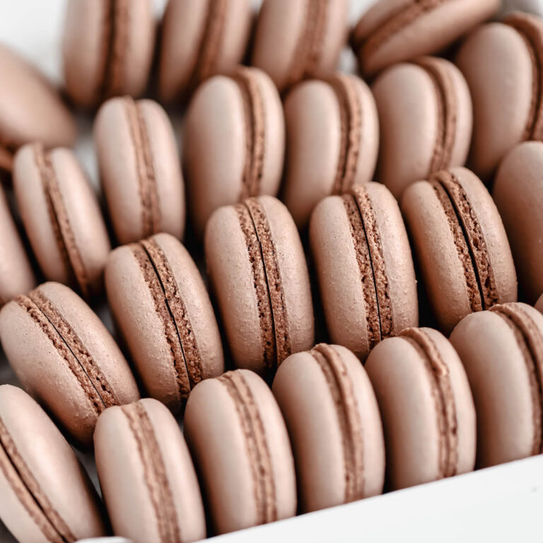 Chocolate macaron shells in the box.