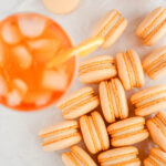 Orange macarons with Aperol drink on the table.
