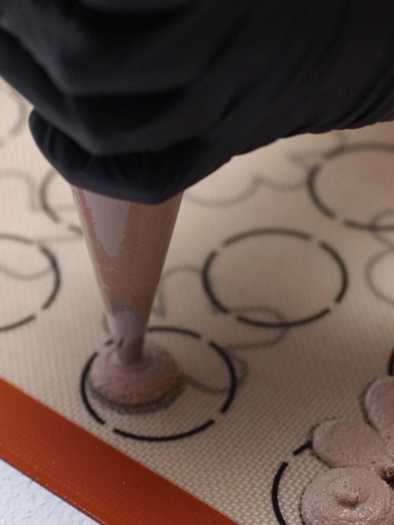 Piping gingerbread man macarons. 