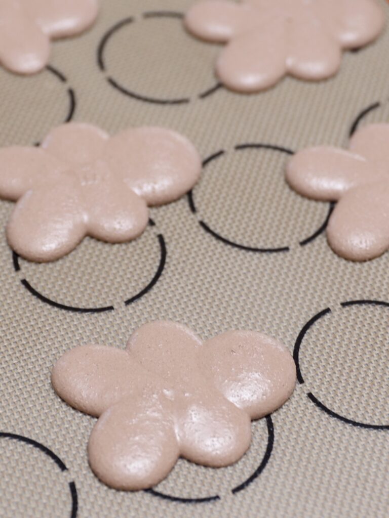 Piping gingerbread man macarons. 