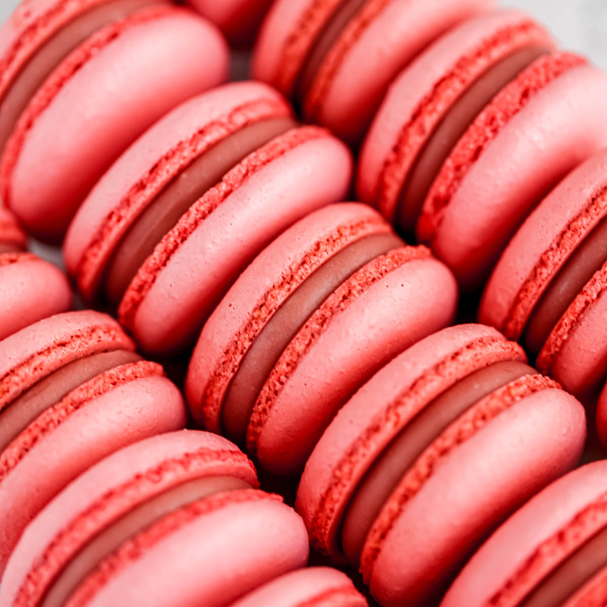 Pink macarons are placed on the table.