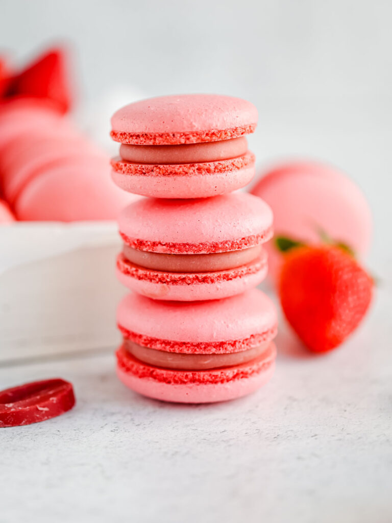 Pink macarons are stocked on the table. 