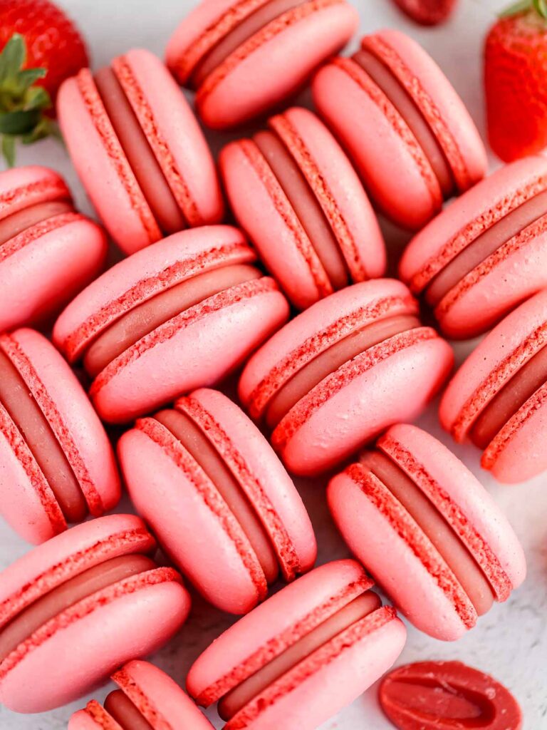 Pink macarons are placed on the table.