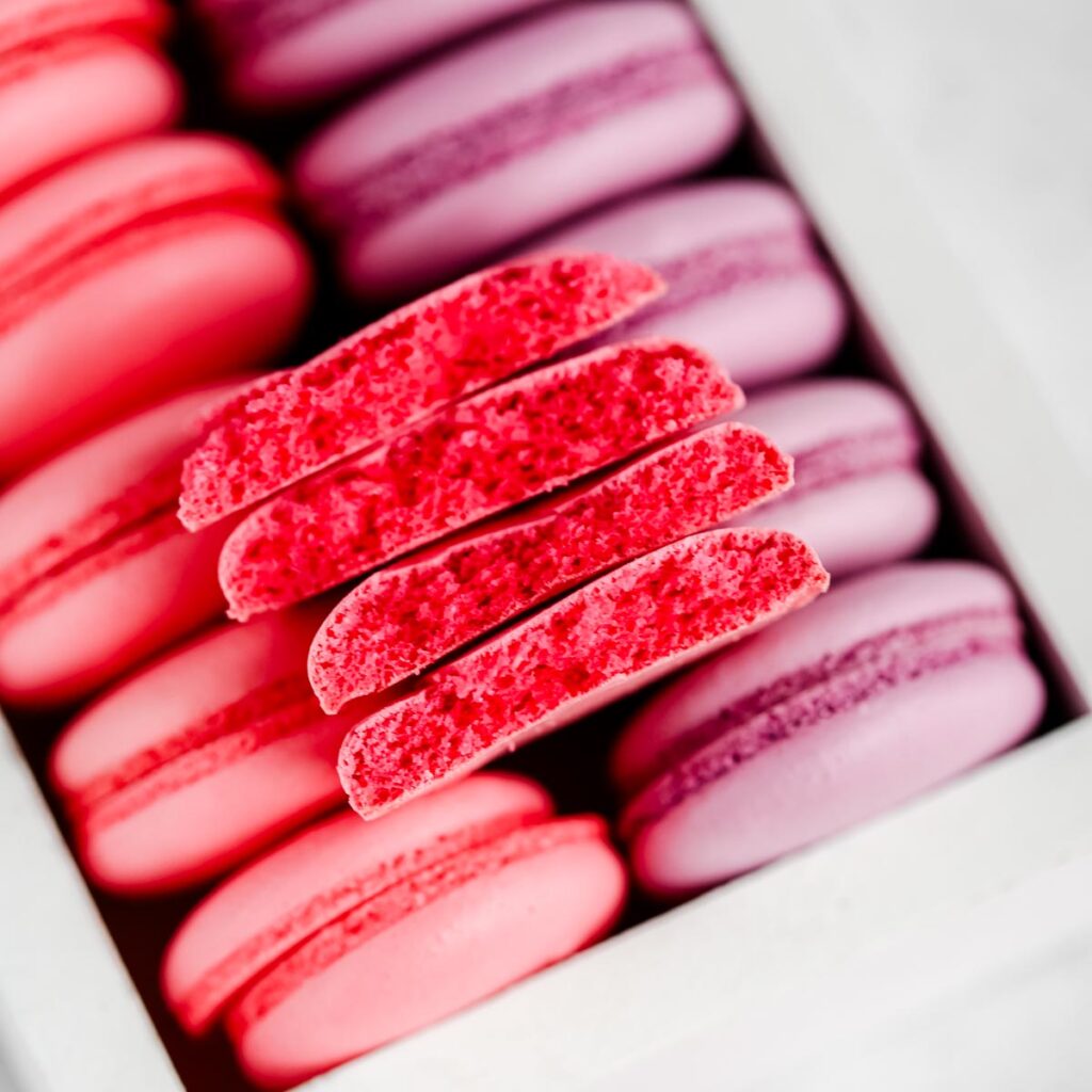 Pink and purple macaron shells in the box.