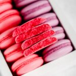 Pink and purple macaron shells in the box.