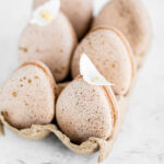 Egg-shaped macarons in the carton egg container.