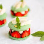 Green macaron shells filled with fresh strawberries and cream.