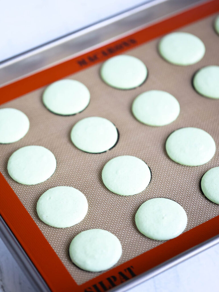 Macarons piped on the baking mat. 