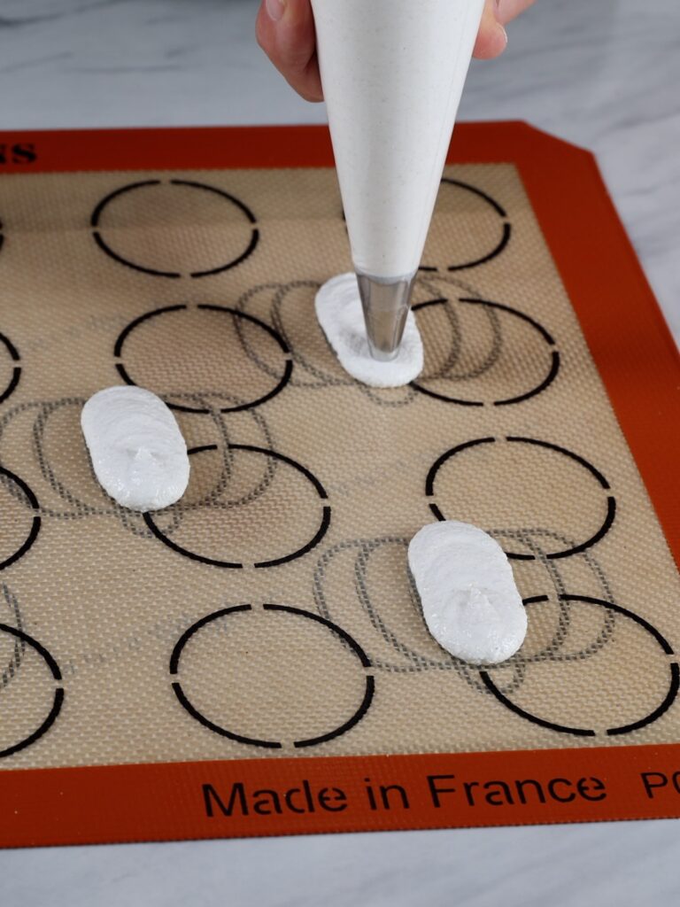 Piping the middle part of the pumpkin-shaped macaron.