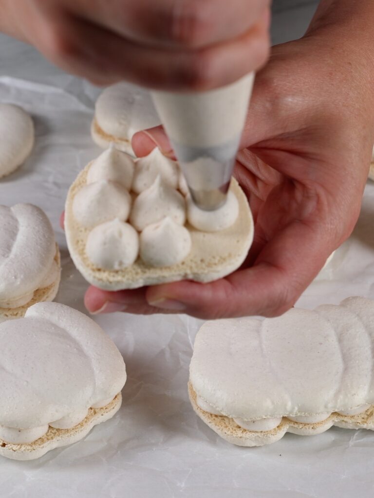 Piping buttercream on the macaron shell.