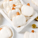 White macarons are shaped like pumpkins.