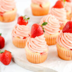 Cupcakes with frosting and fresh strawberry on top.