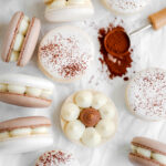 Brown and white macarons on the table.