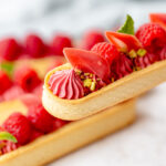 Tart with raspberry cream decorated with fresh raspberries.