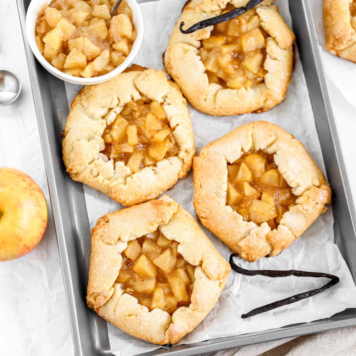 Mini apple galettes on the baking tray.