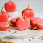 Red apple-shaped macarons on the table.