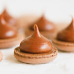 Milk chocolate ganache piped on the flat side of macaron shell.