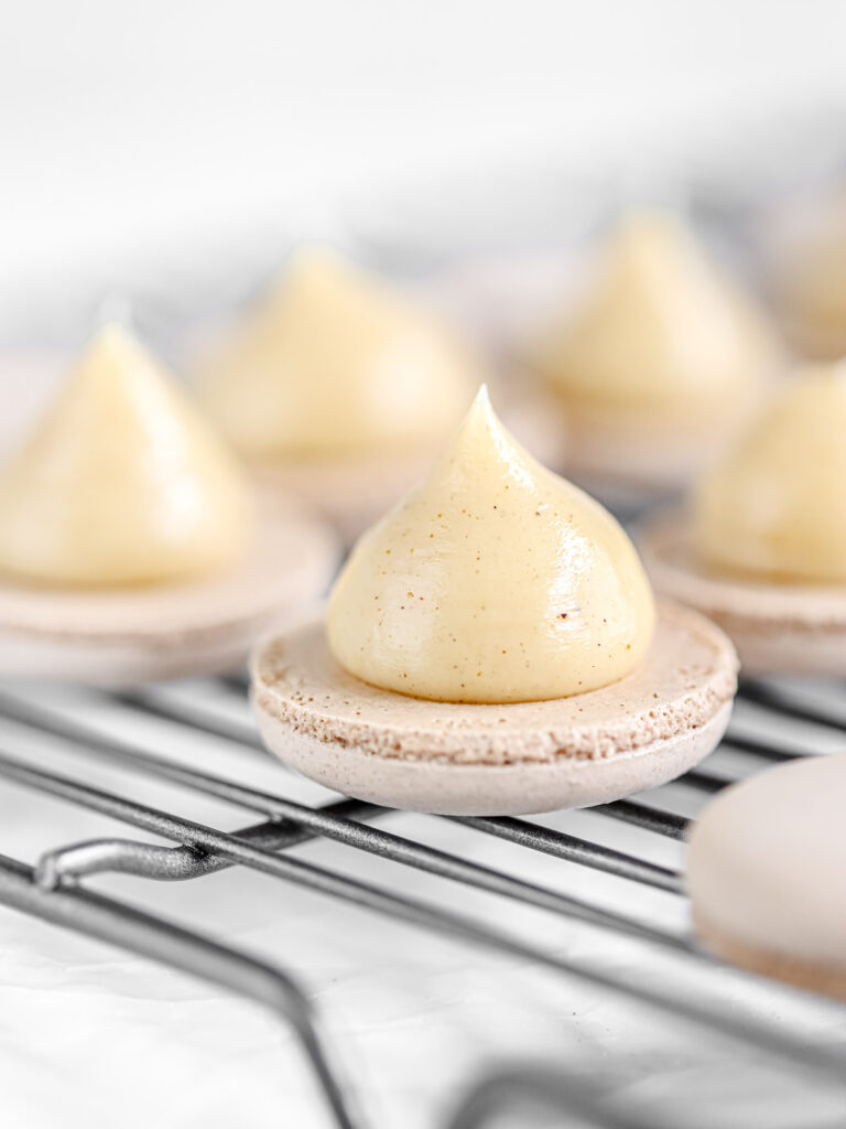 Gingerbread ganache piped on macaron shells. 