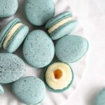 Egg-shaped macarons on the plate.