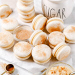 White macaron shells sprinkled with cinnamon sugar.