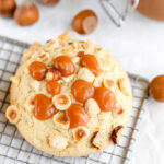 The cookie is decorated with hazelnuts and caramel on the wire rock.