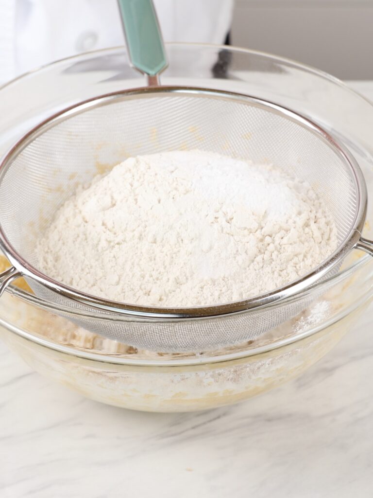 Sifting flour into cookie butter. 