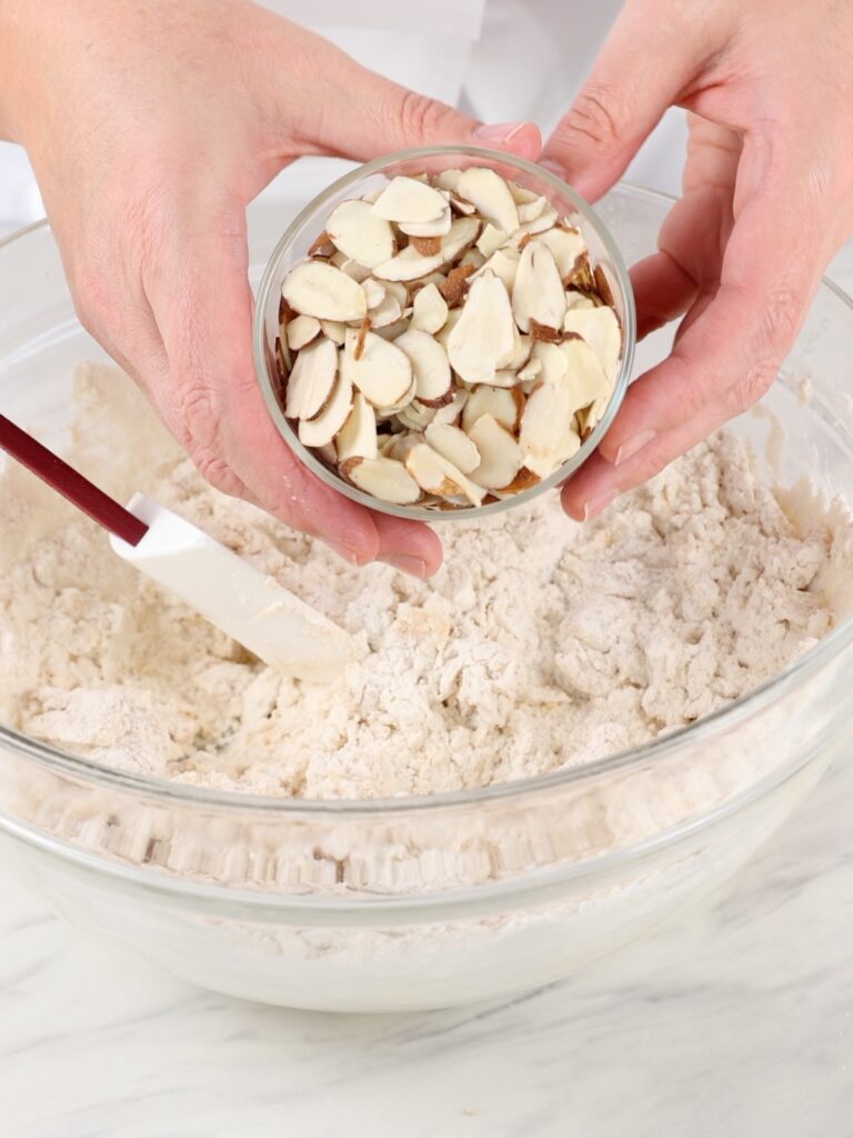 Adding sliced almonds to cookie butter. 