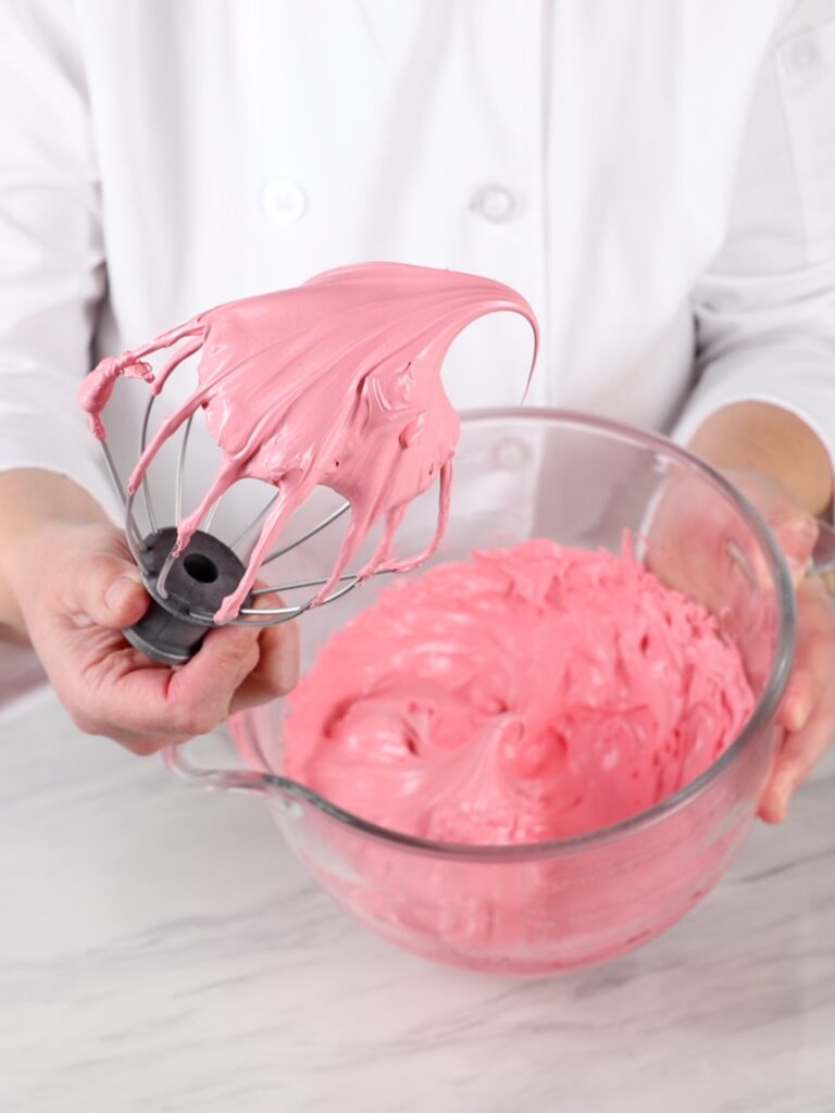 Pink stiff meringue on the whisk.