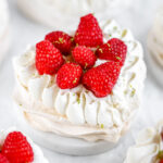 Heart shaped pavlova decorated with fresh raspberries.