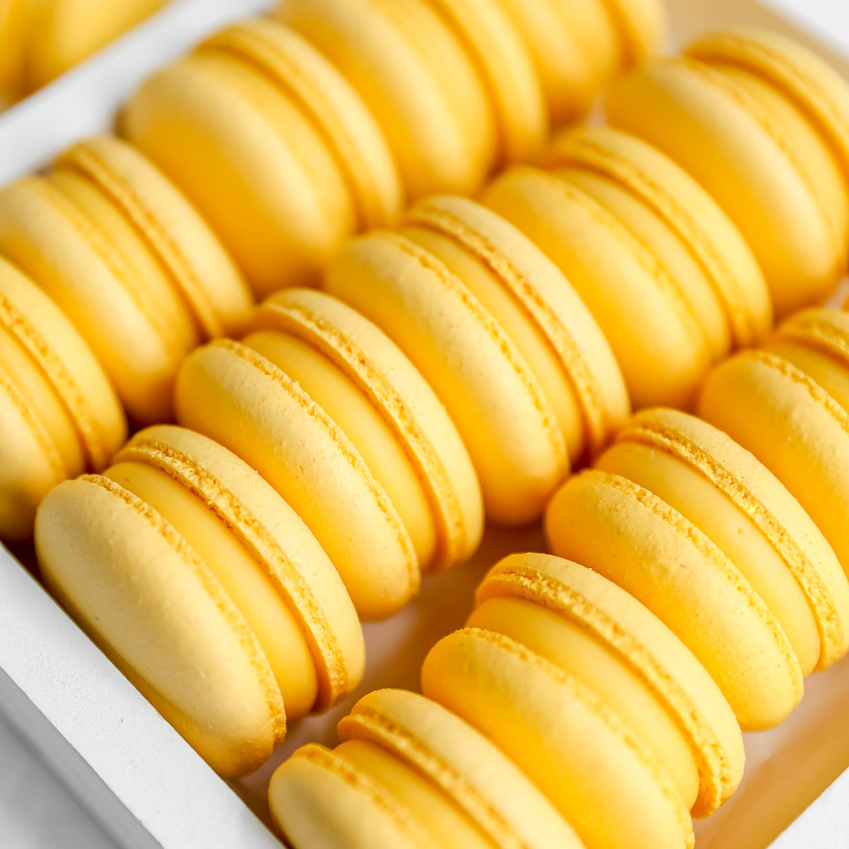 Yellow mango macarons in the white box.
