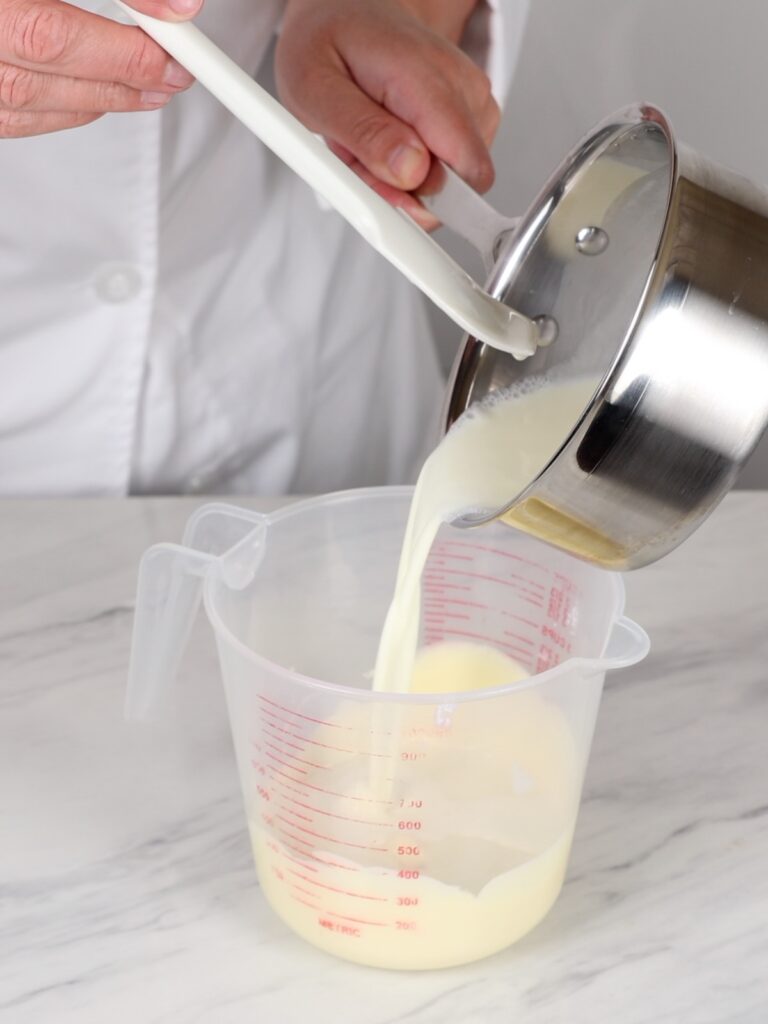 Adding heavy cream to melted chocolate. 