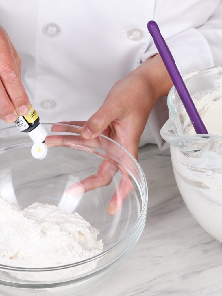 Adding food coloring to the macaron batter. 