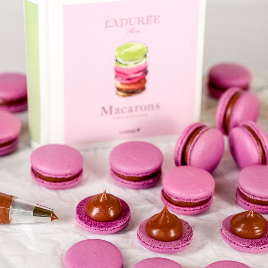 Ladurée macarons book with macarons on the table.