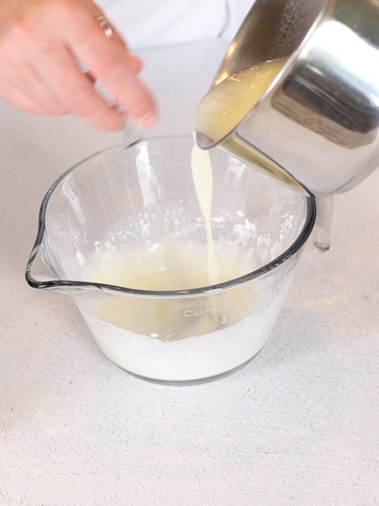 Pouring heavy cream into a mixing bowl. 