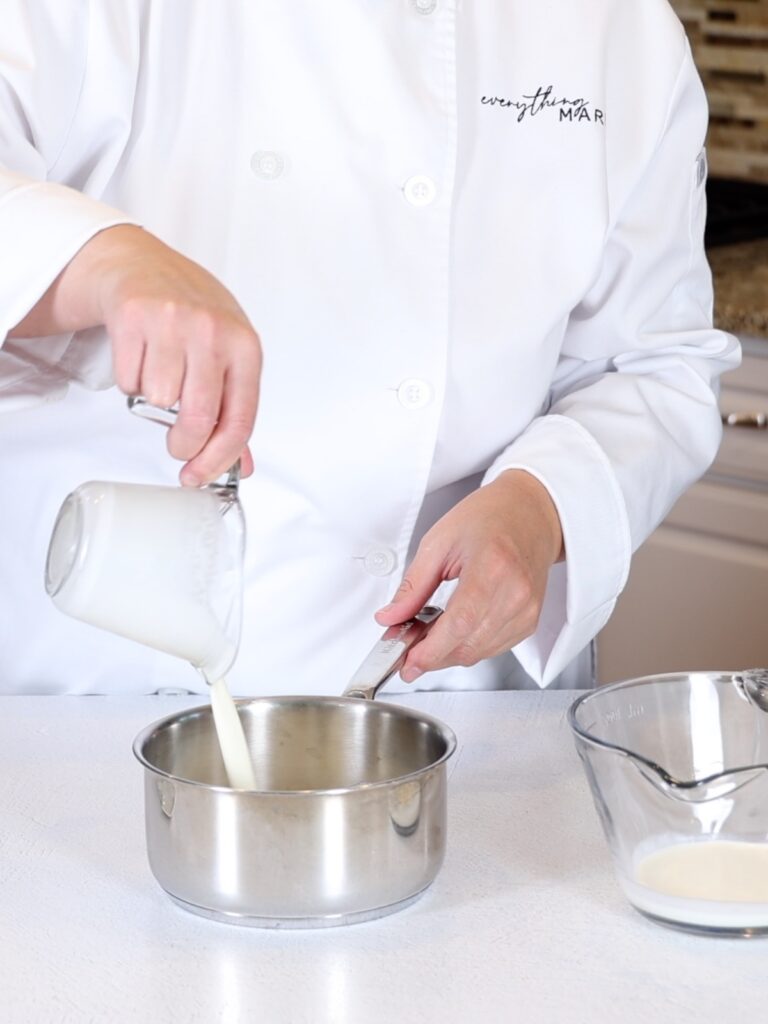 Pouring heavy cream into a saucepan. 