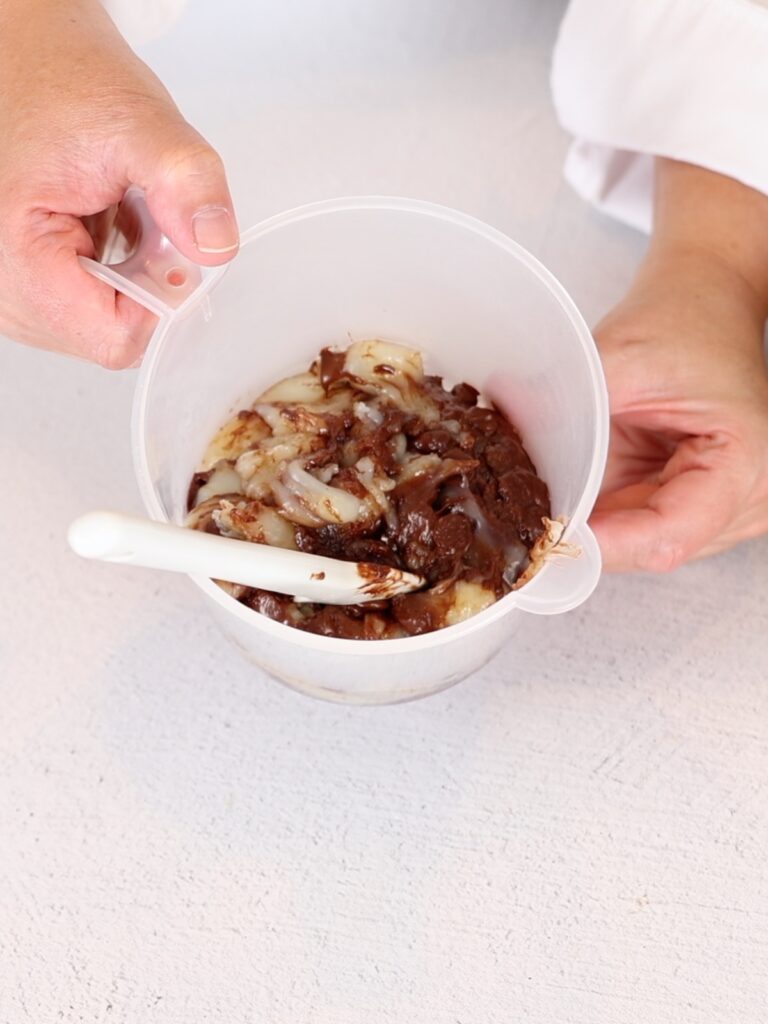 Pastry cream and dark chocolate in a plastic cup.