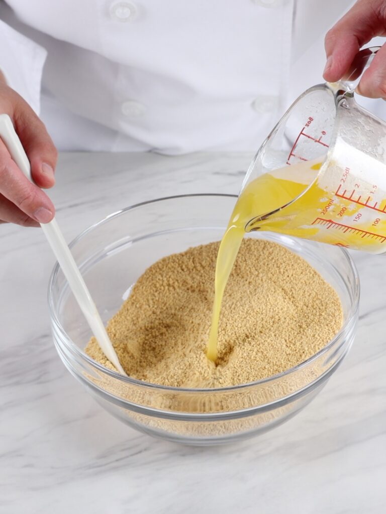 Melting butter pouring over the crumbs. 