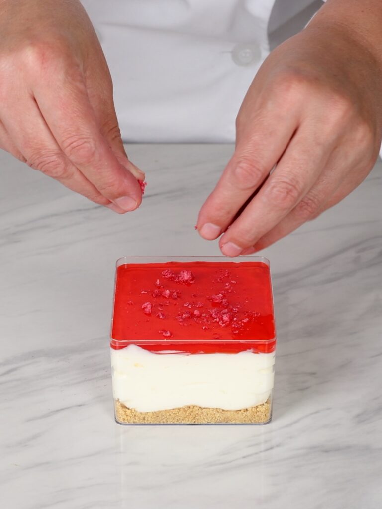 Adding friezed dried raspberries to the jello. 