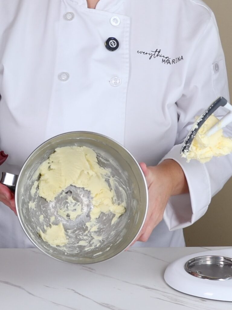Hands are holding a mixing bowl with butter.