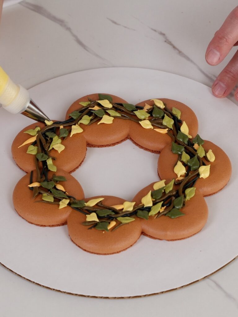 Hand is decorating a macaron wreath.
