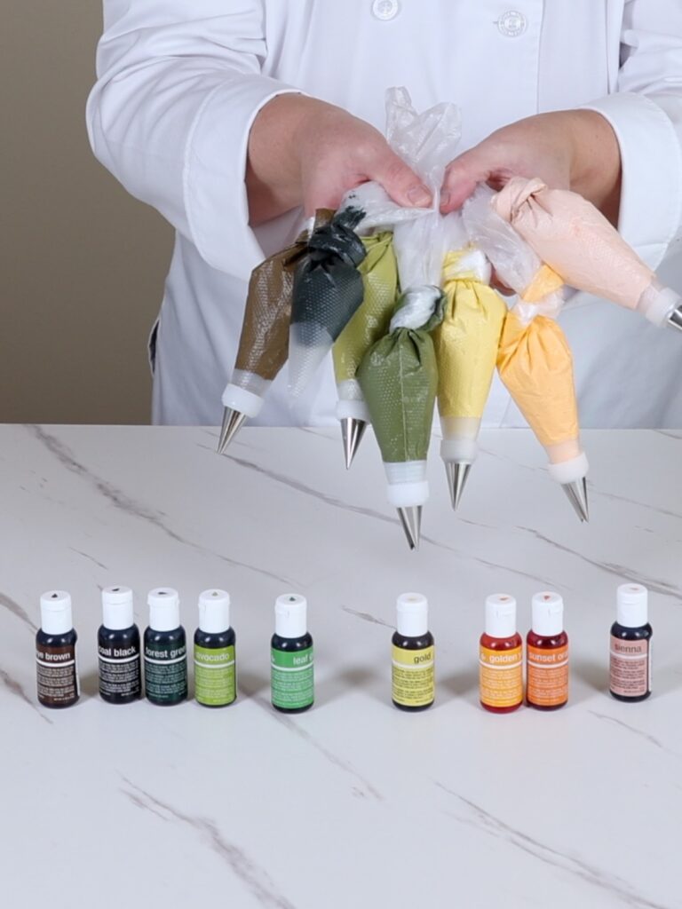 Hands are holding bags with royal icing.