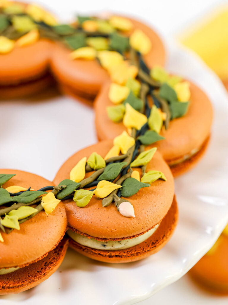 Brown wreath macarons decorated with icing leaves.